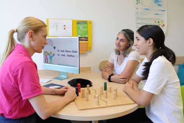 Eine Mutter sitzt mit Ihrer Tochter einer empathischen Kinderpsychologin gegen&uuml;ber