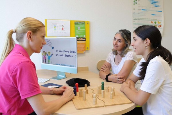 Eine Mutter sitzt mit Ihrer Tochter einer empathischen Kinderpsychologin gegen&uuml;ber