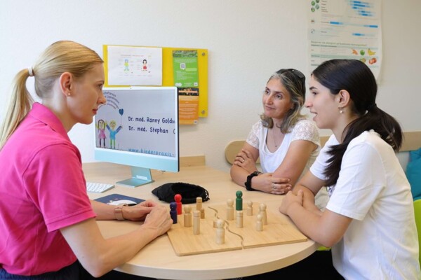 Eine Mutter sitzt mit Ihrer Tochter einer empathischen Kinderpsychologin gegen&uuml;ber